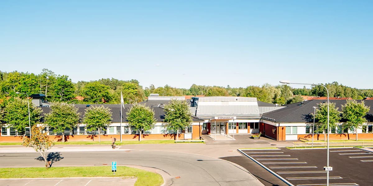En tom parkeringsplats framför en skola