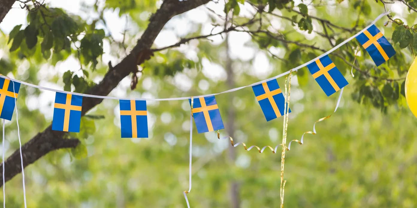 Ett gäng blågula flaggor som hänger i ett träd.