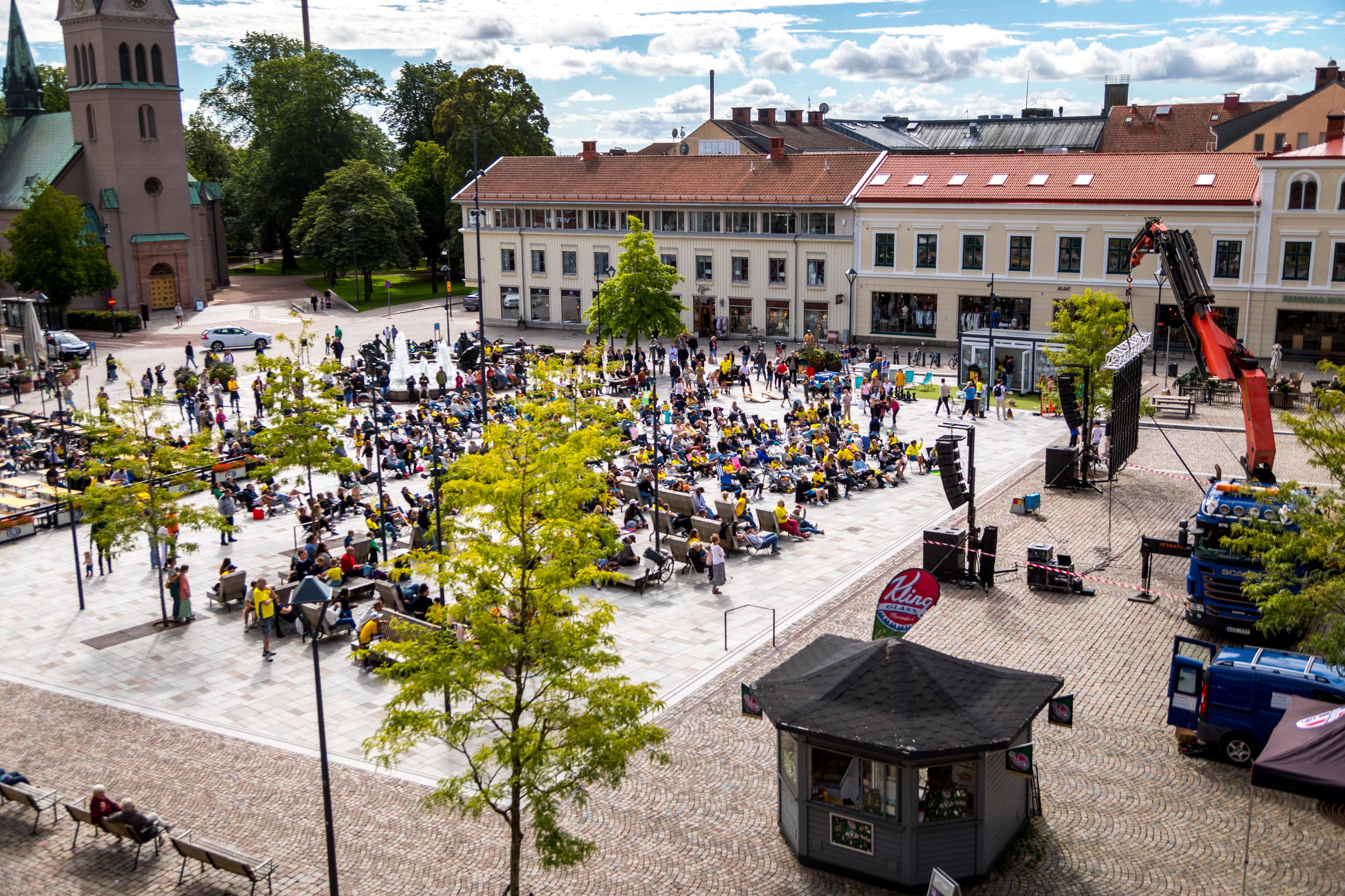 Många människor som sitter och chillar på ett torg