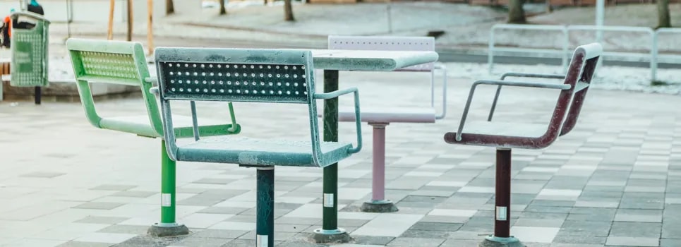 En rad parkbänkar som sitter på ett rutigt golv.