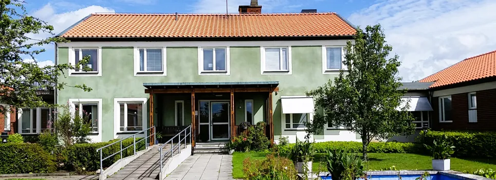 Ett hus med en fontän framför.
