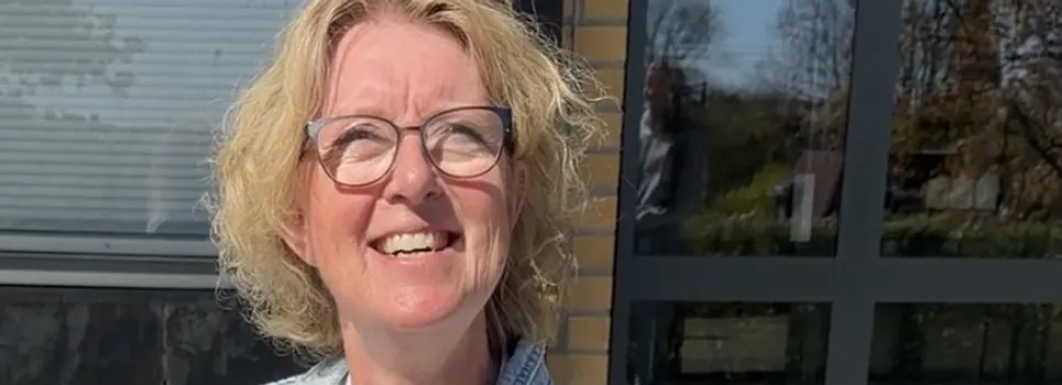 En kvinna som sitter på en svart bänk.