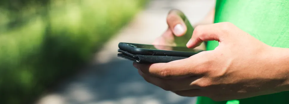 En person som håller en mobiltelefon i handen.